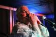 Ken Rhyne, Legendary Blues Player and Principal with Urban Design Group, plays the harmonica at Blues and Q's.